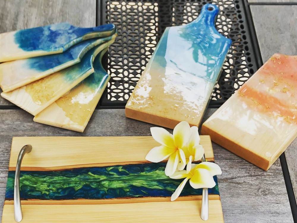 Serving and charcuterie boards with blue, teal and sunset-colored resin rivers