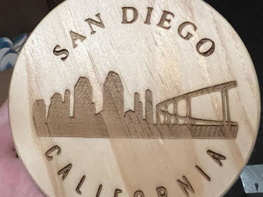 A wooden round engraved with the San Diego skyline and the words San Diego California