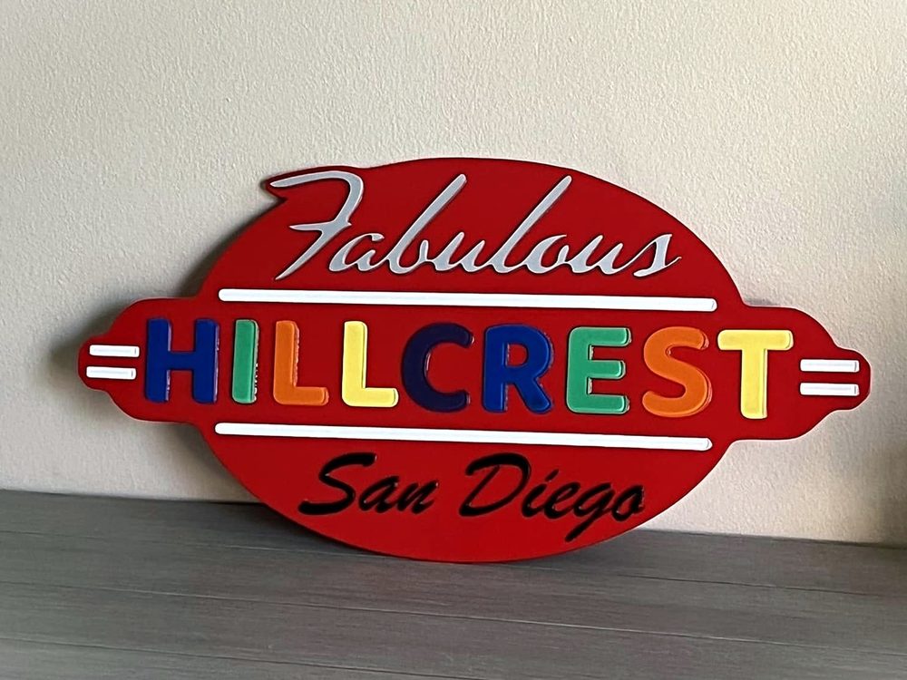 A layered wood sign reading Fabulous Hillcrest San Diego in red with multicolored letters